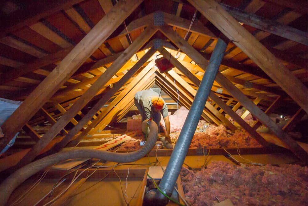 a professional using equipment to clean out an attic